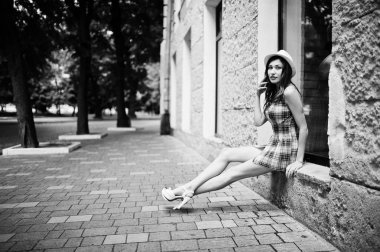 Hig topuklu kız ile şaşırtıcı uzun bacaklı giymek oturan şapka