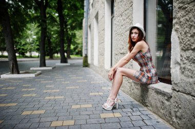 Hig topuklu kız ile şaşırtıcı uzun bacaklı giymek oturan şapka