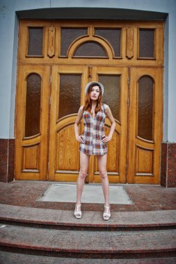 Şaşırtıcı uzun bacaklı kız giymek karşı poz şapka hig topuklu