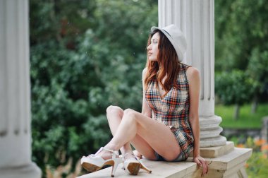 Hig topuklu kız ile şaşırtıcı uzun bacaklı v oturan şapka giymek