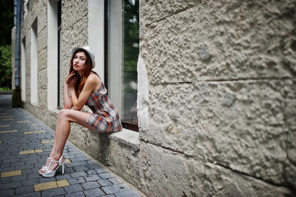 Hig topuklu kız ile şaşırtıcı uzun bacaklı giymek oturan şapka