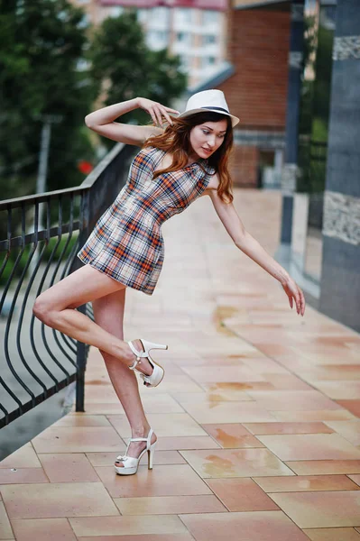 Increíbles piernas largas con tacones de la cadera chica usar en el sombrero posando cerca de th —  Fotos de Stock