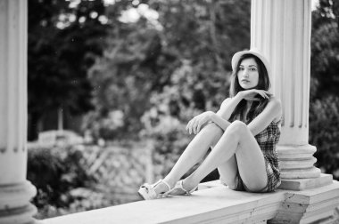 Hig topuklu kız ile şaşırtıcı uzun bacaklı v oturan şapka giymek