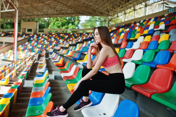 Γυμναστήριο σπορ κορίτσι σε αθλητικά ενδύματα που κάθεται στο στάδιο καρέκλες εξωτερι — Φωτογραφία Αρχείου