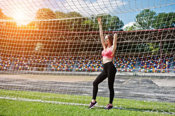 Fitness sporty girl in sportswear and sunglasses posed at stadiu — Stock Photo, Image