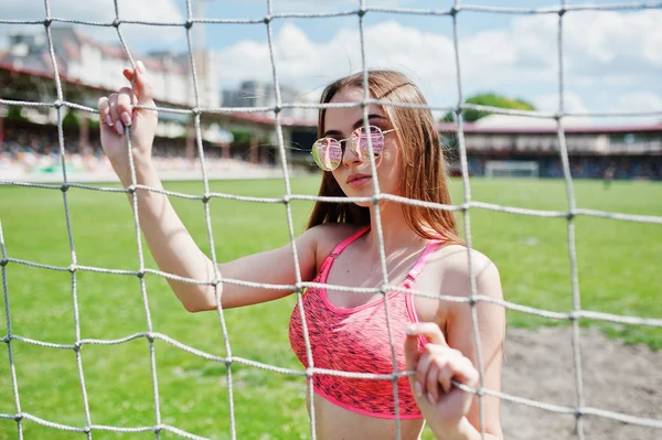 Sportliches Mädchen in Sportbekleidung und Sonnenbrille posierte im Stadion — Stockfoto