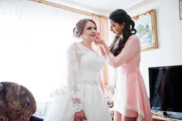 그녀의 결혼식 귀걸이에 신부를 돕는 아름 다운 신부 들러리 — 스톡 사진
