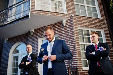 Onun yakışıklı Damat Düğün sağdıç ile poz smokin veya olmak