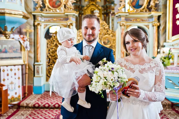 Casal feliz na igreja com sua filha bebê — Fotografia de Stock