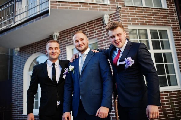 Knappe bruidegom in zijn bruiloft tuxedo poseren met groomsmen of worden — Stockfoto