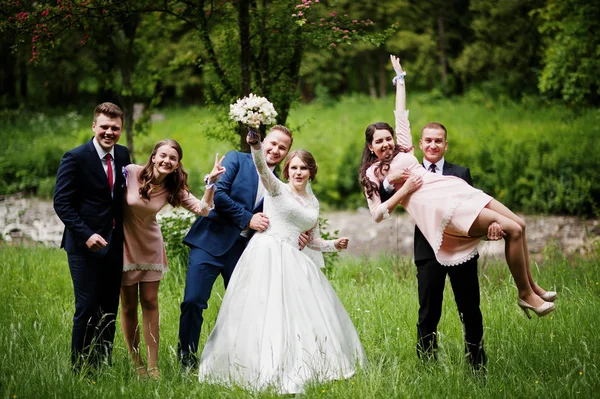 Pengantin baru yang gila dan bahagia bersenang-senang dengan pengiring pengantin dan pengantin pria — Stok Foto