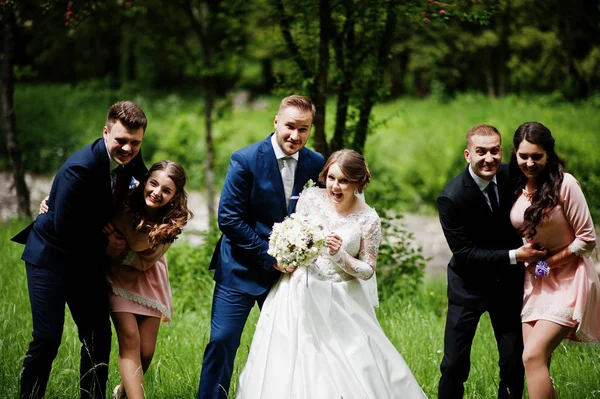 Fou et heureux jeunes mariés s'amuser avec les demoiselles d'honneur et les mariés — Photo