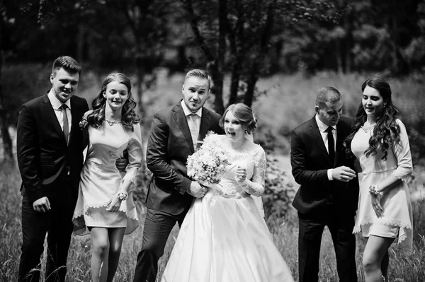 Gek en gelukkig jonggehuwden plezier met bruidsmeisjes en bruidsparen — Stockfoto