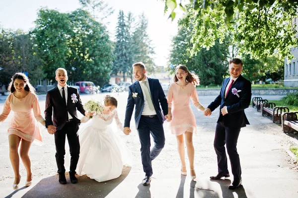 Glückliches Hochzeitspaar und Brautpaare mit Trauzeugen beim Laufen und — Stockfoto