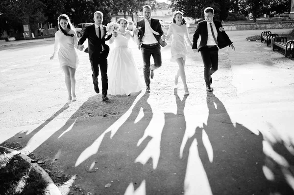 Glückliches Hochzeitspaar und Brautpaare mit Trauzeugen beim Laufen und — Stockfoto