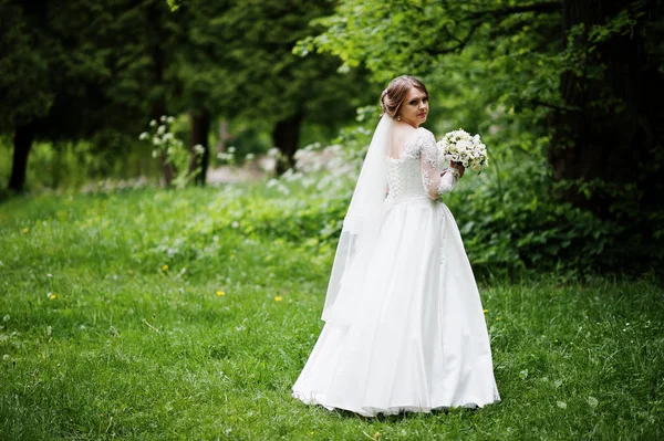 Portrait d'une belle jeune mariée posant avec un bouquet outdoo — Photo