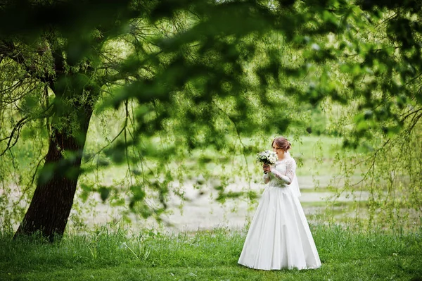 Portrait d'une belle jeune mariée posant avec un bouquet outdoo — Photo