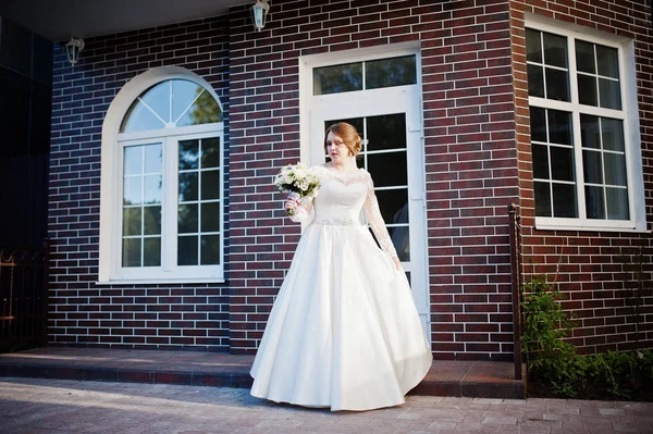 Portret van een aantrekkelijke bruid spinnen voor een wit huis — Stockfoto