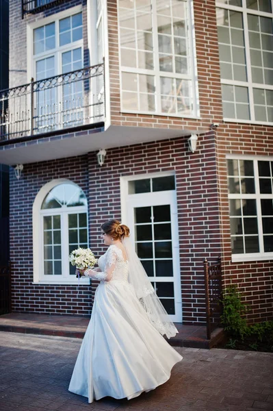 Retrato de uma noiva atraente girando na frente de uma casa sagacidade — Fotografia de Stock
