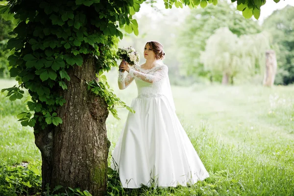 Portrait d'une belle jeune mariée posant avec un bouquet outdoo — Photo