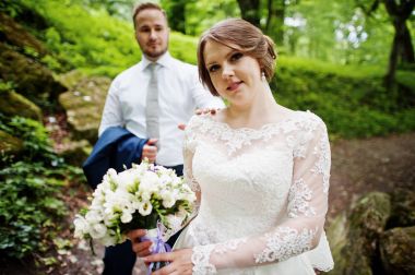 Ormanın içinde arka planda büyük kayalar ile poz yeni evliler