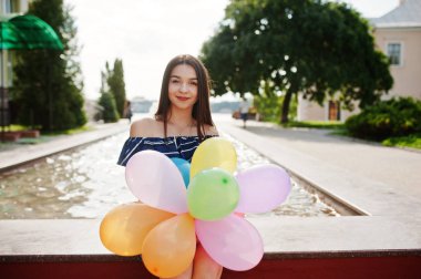 Güzel esmer kız elinde balonlarla Street City.