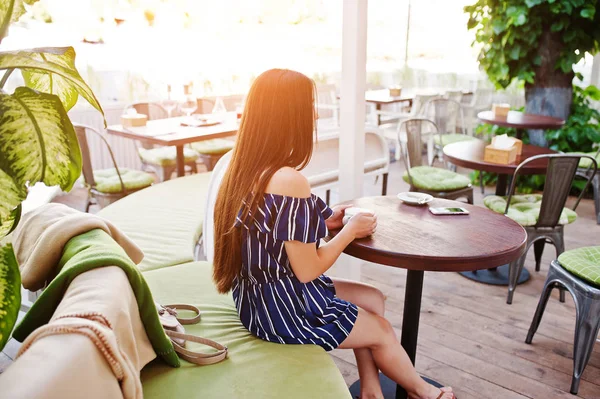 Superbe fille brune assise sur la table dans un café avec une tasse de — Photo