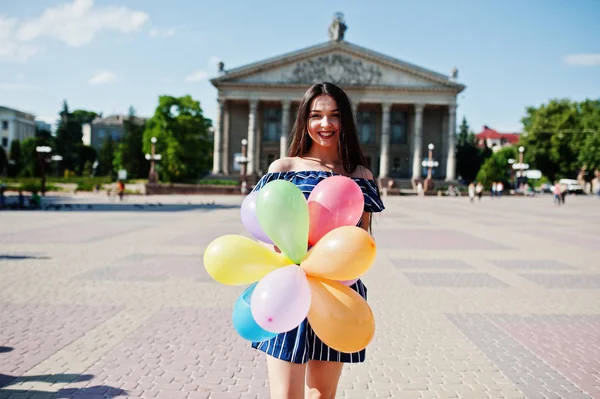 Gorgeous brunette girl at street of city with balloons at hands. — Stock Photo, Image