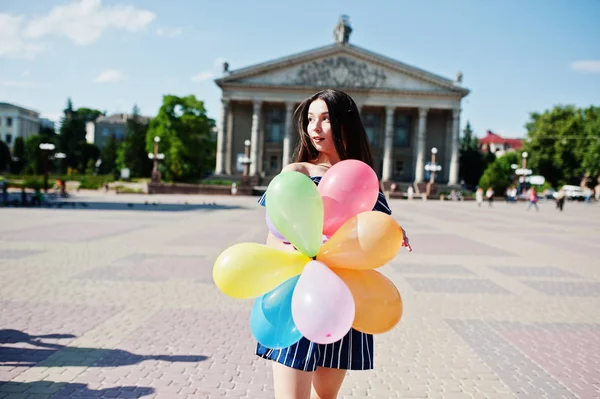 Gorgeous brunetka dziewczyna na ulicy miasta z balonami w ręce. — Zdjęcie stockowe