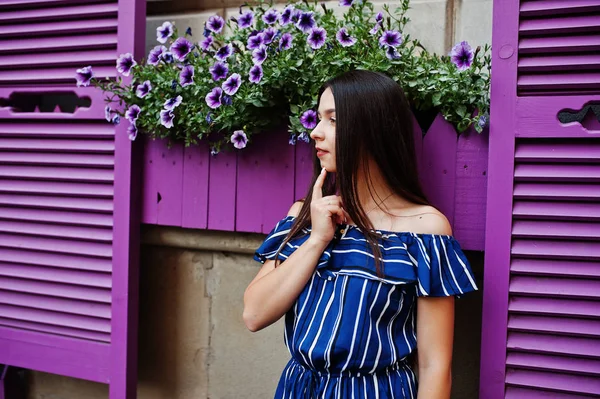 Ursnygg brunett flicka stående bakgrund violett windows. — Stockfoto