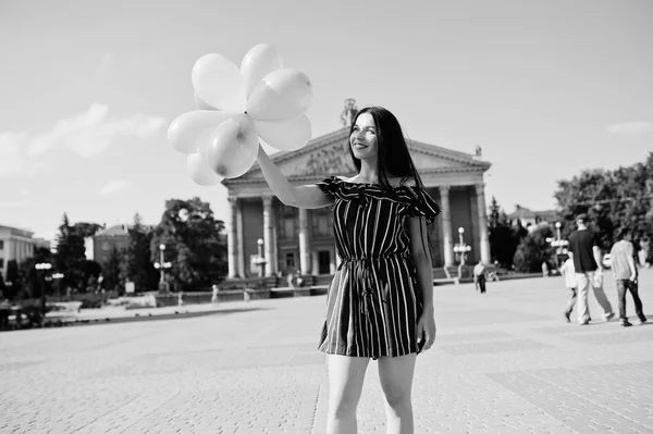 Gorgeous brunette girl at street of city with balloons at hands. — Stock Photo, Image