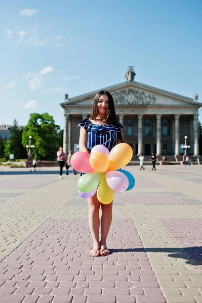 Wunderschöne brünette Mädchen auf der Straße der Stadt mit Luftballons an den Händen. — Stockfoto