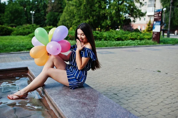 Wunderschöne brünette Mädchen auf der Straße der Stadt mit Luftballons an den Händen. — Stockfoto