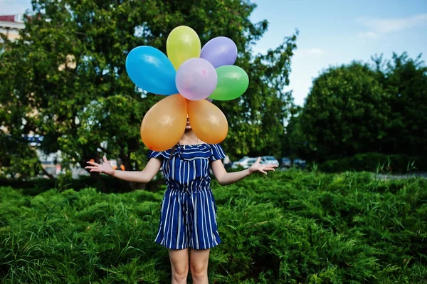 Ursnygg brunett flicka på gatan av staden med ballonger på händerna. — Stockfoto