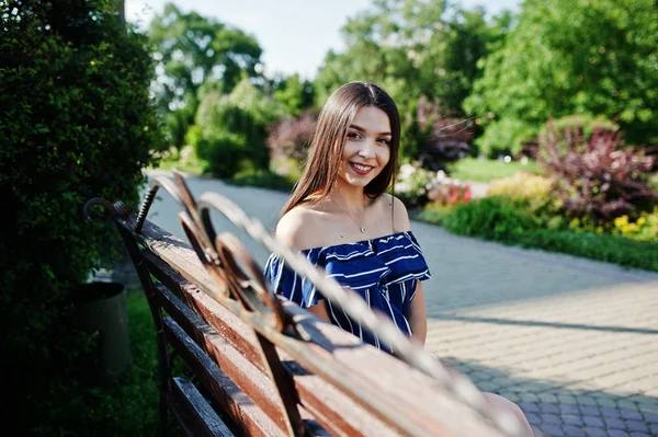 Wunderschöne Brünette Mädchen sitzt auf Bank in der Straße der Stadt tragen o — Stockfoto