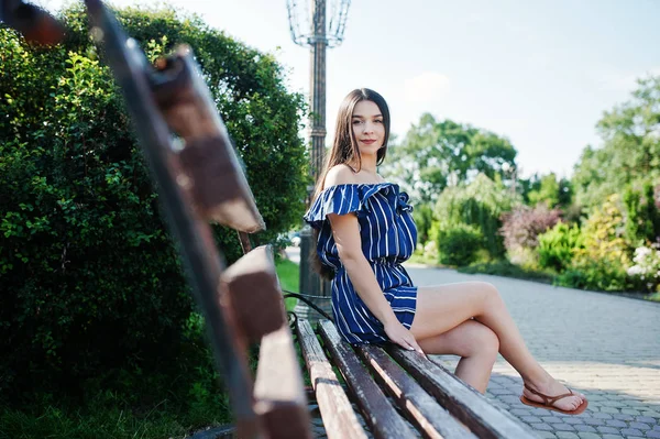 Wunderschöne Brünette Mädchen sitzt auf Bank in der Straße der Stadt tragen o — Stockfoto