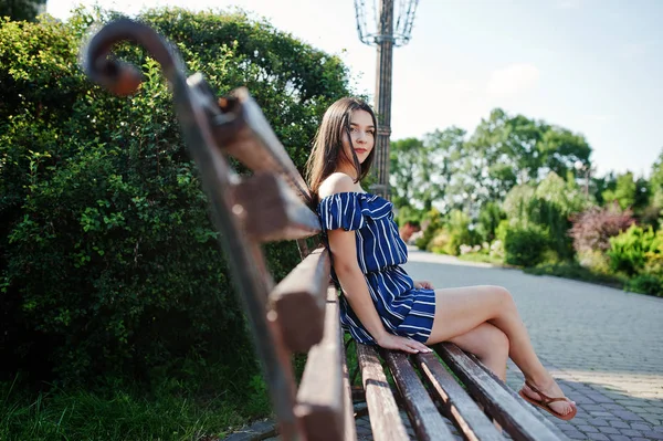 Wunderschöne Brünette Mädchen sitzt auf Bank in der Straße der Stadt tragen o — Stockfoto