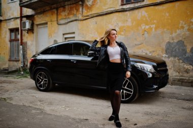 Zarif sarışın kız giymek siyah deri ceket stree poz