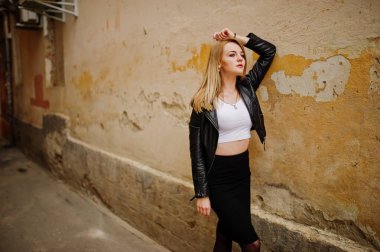 Zarif sarışın kız giymek siyah deri ceket stree poz