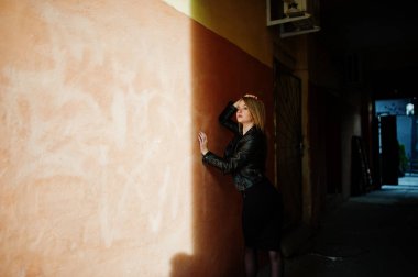 Zarif sarışın kız giymek siyah deri ceket stree poz