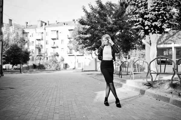 Elegantes blondes Mädchen in schwarzer Lederjacke posiert am Baum — Stockfoto