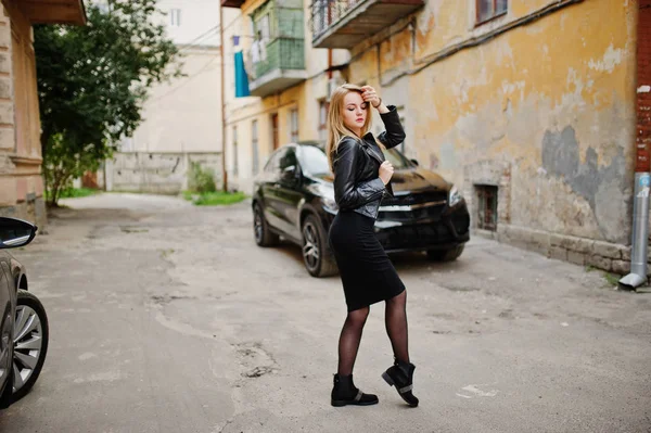 Elegáns szőke lány viselni a fekete bőr kabát: stree pózol — Stock Fotó