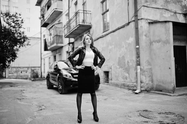 Элегантная блондинка одевается в черную кожаную куртку, позируя на улице — стоковое фото