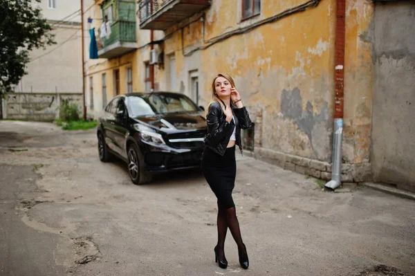 Elegante ropa de niña rubia en chaqueta de cuero negro posando en stree — Foto de Stock