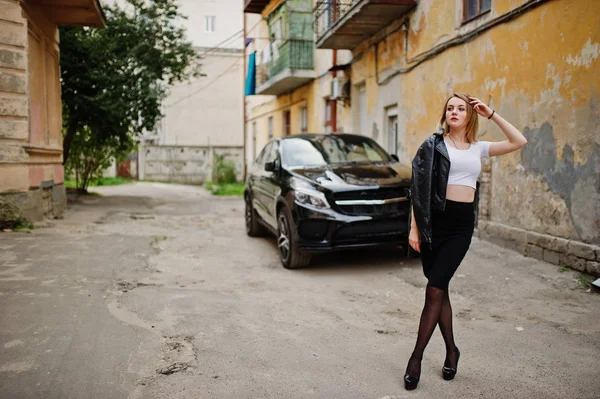 Элегантная блондинка одевается в черную кожаную куртку, позируя на улице — стоковое фото