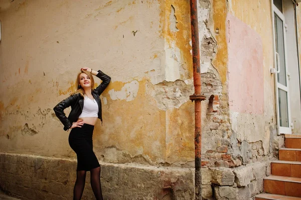 Elegant blond flicka bära på svart skinnjacka poserar på stree — Stockfoto