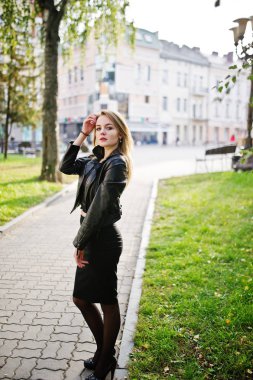 Zarif sarışın kız giymek siyah deri ceket stree poz