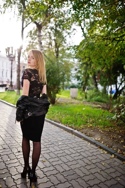 Elegant blonda fata purta pe negru jacheta din piele pozand la copac — Fotografie, imagine de stoc