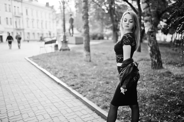 Elegante ropa de niña rubia en chaqueta de cuero negro posando en stree — Foto de Stock