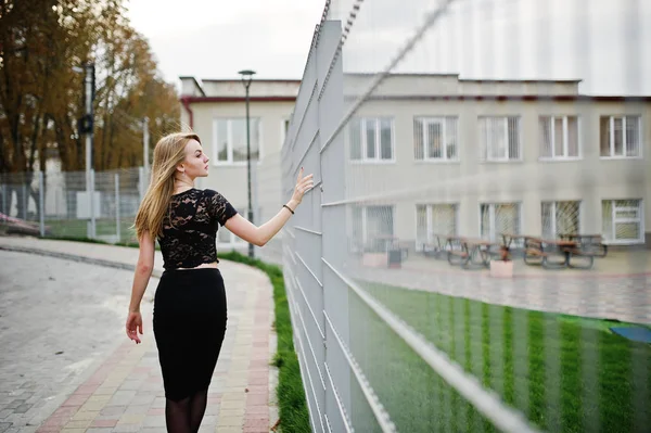 Elegant blond flicka bära på svart poserar på gatorna i staden Mo — Stockfoto